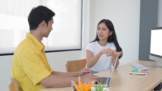 Jovem criativa compartilhando ideias ou plano de negócios de inicialização com seu colega