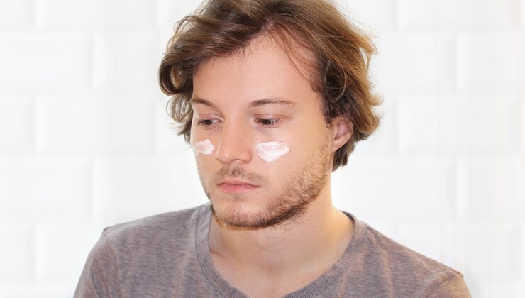 Foto jovem cuidando de suas rugas debaixo dos olhos aplicando máscara facial aplicando o creme
