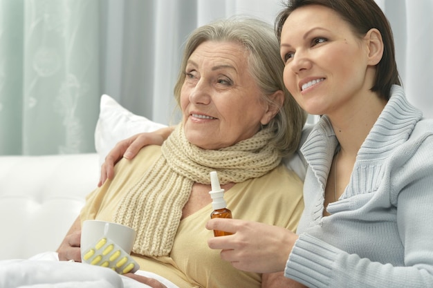 Jovem cuidando de uma mulher idosa doente