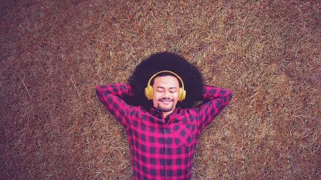 Jovem curtindo música enquanto estava deitado no parque