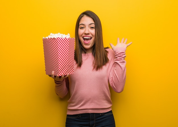 Jovem, cute, mulher segura, um, pipoca, balde, celebrando, um, vitória, ou, sucesso