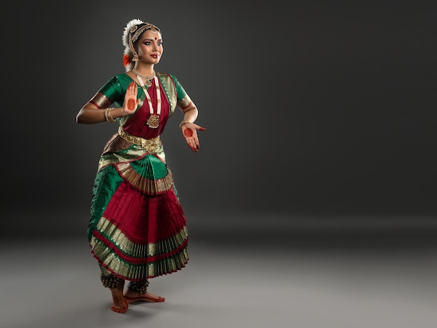 Jovem dançarina atraente da dança clássica indiana bharatanatyam está demonstrando pose simbólica