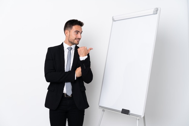 Jovem dando uma apresentação no quadro branco e apontando para o lado