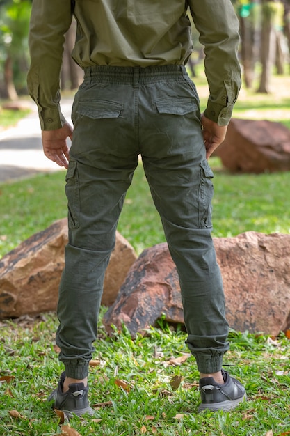 Foto jovem de calça verde parado no parque