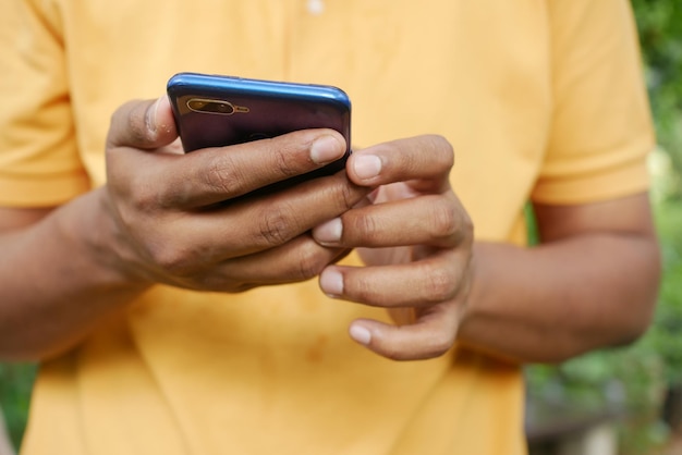 Jovem de camisa amarela usando telefone inteligente