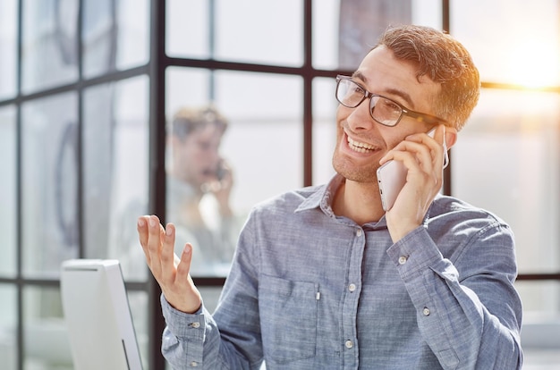 Jovem de camisa azul falando ao telefone