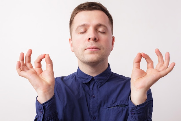 Jovem de camisa azul respirando profundamente tentando acalmar Dedos juntos seus olhos cobertos