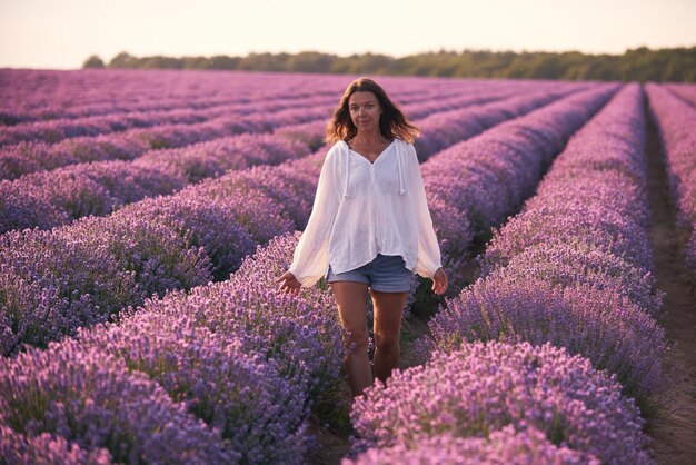 Jovem de camisa branca no belo campo de lavanda