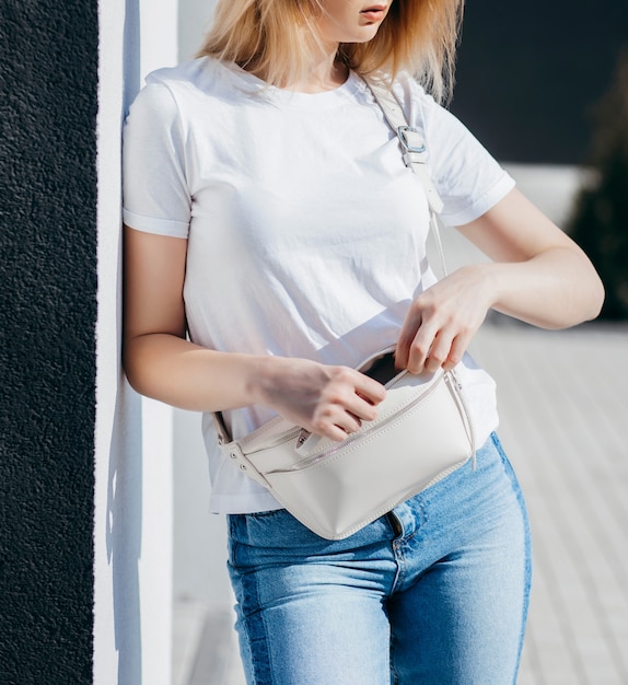 Foto jovem de camisa e calça jeans posando ao ar livre