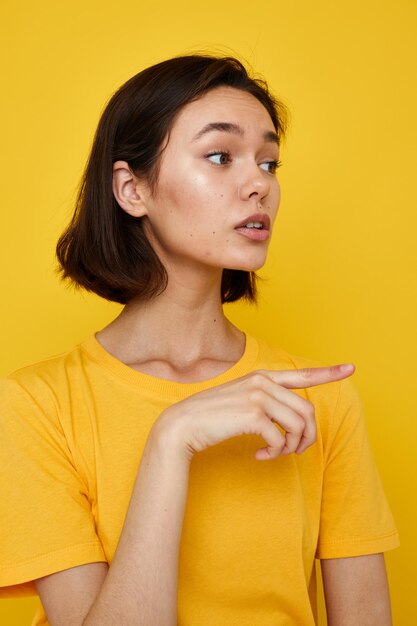 Jovem de camiseta amarela posando fundo amarelo de moda