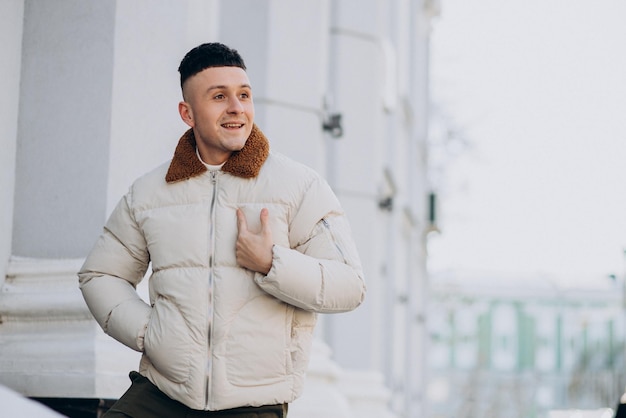 Jovem de casaco de inverno branco fora da rua