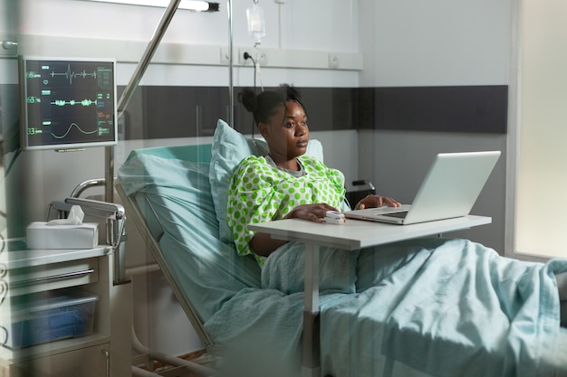 Jovem de etnia africana navegando na Internet no laptop