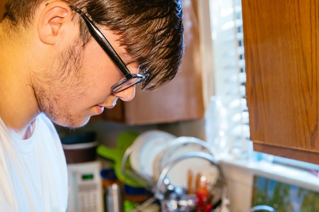 Jovem de família única na cozinha cozinhando