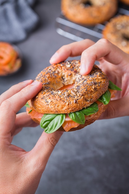 Jovem de mãos dadas e pronto para comer bagels com salmão defumado