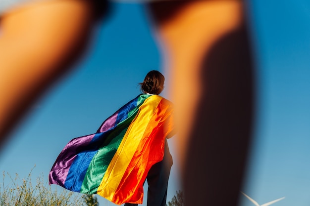 Jovem de meia idade por trás com a bandeira LGTBI. Imagem tirada entre as pernas de seu filho de 3 anos. adpocion. inseminação