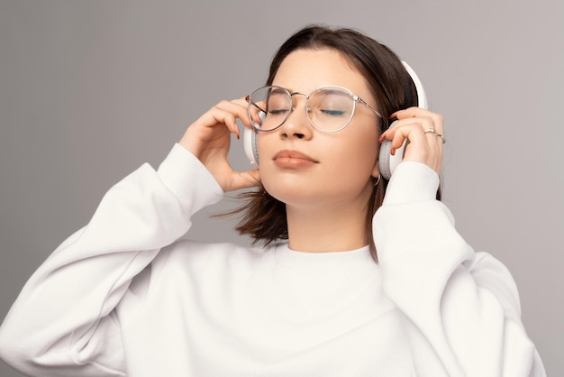 Jovem de óculos e fones de ouvido gosta de música e seu tempo sozinho