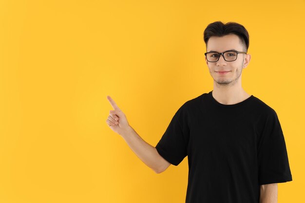 Jovem de óculos em fundo amarelo