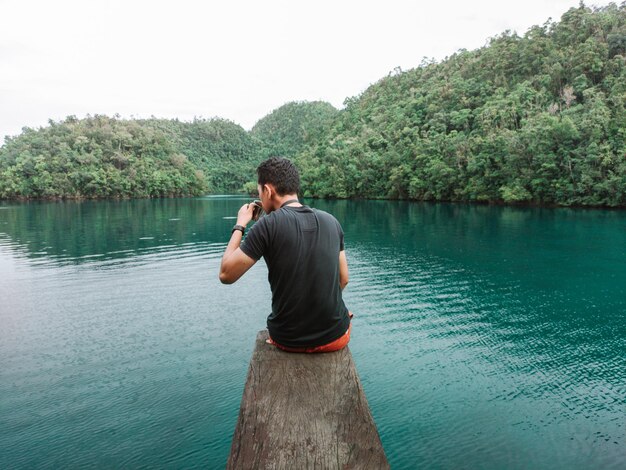 Foto jovem de pé ao lado do lago