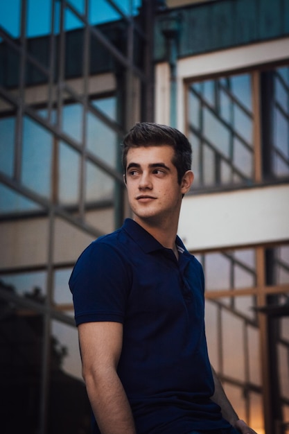 Jovem de pé contra o edifício