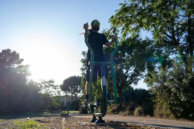 Jovem de pé em equipamentos de exercício no parque