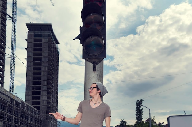 Foto jovem de pé junto ao sinal de estrada na cidade
