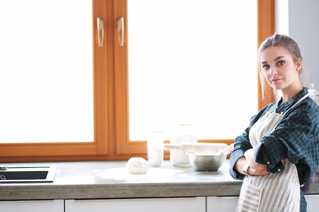 Jovem de pé perto da mesa na cozinha