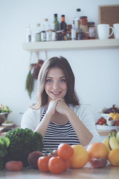 Jovem de pé perto da mesa na cozinha