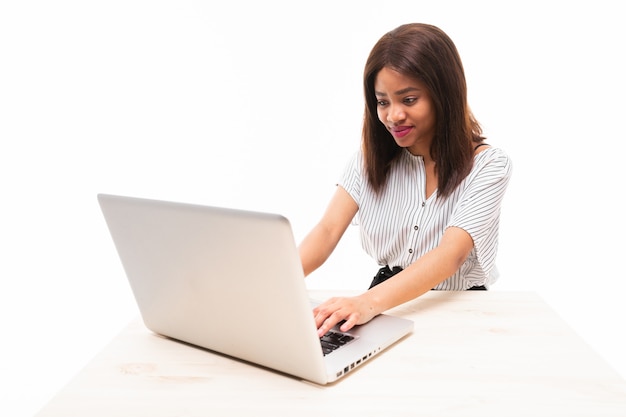 Jovem de pele escura, digitando no laptop