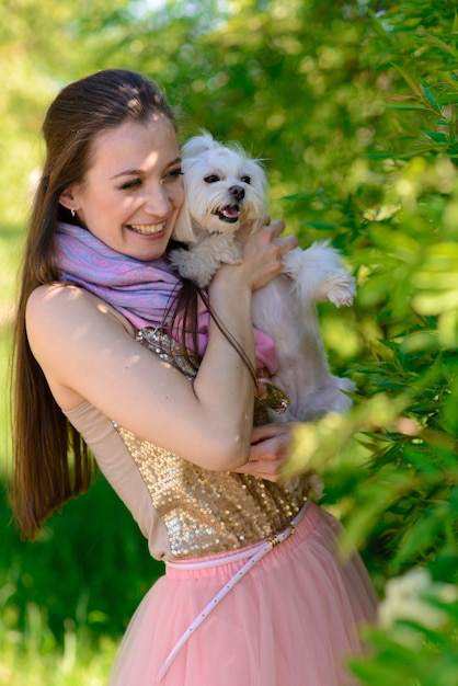 Jovem de saia rosa com o cachorro