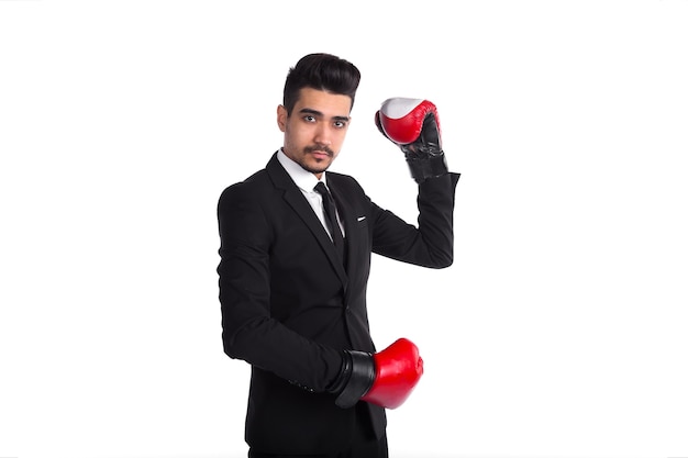 Jovem de terno preto e luvas de boxe vermelhas, posando no estúdio.