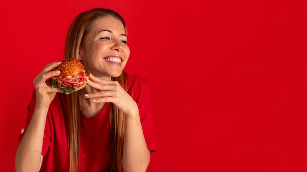 Foto jovem de tiro médio comendo hambúrguer