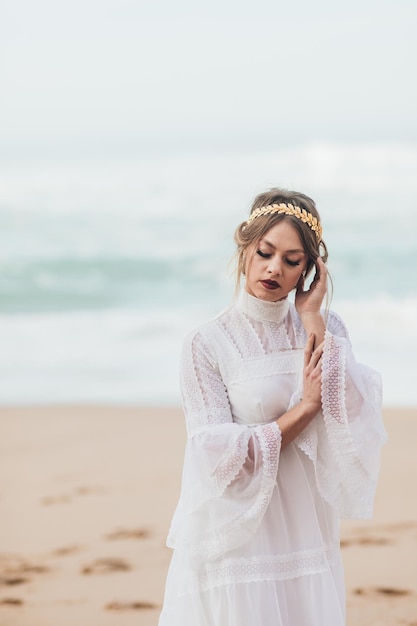 jovem de vestido branco caminhando na praia