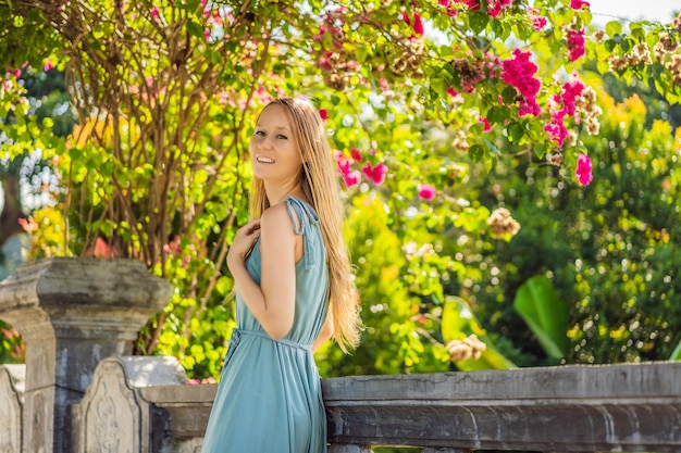 Jovem de vestido no Palácio da Água Soekasada Taman Ujung Ruins na ilha de Bali na Indonésia Arquitetura antiga incrível Fundo de viagens e feriados