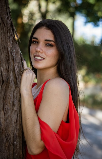 jovem de vestido vermelho em uma floresta curtindo a natureza