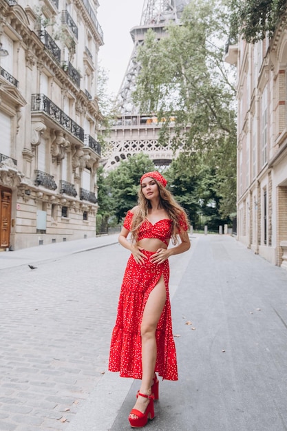 Jovem de vestido vermelho perto da Torre Eiffel em Paris em dia ensolarado de verão