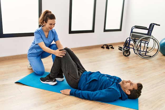 Jovem deficiente fazendo exercício de mobilidade na clínica.