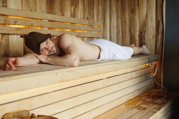Jovem deitado na sauna