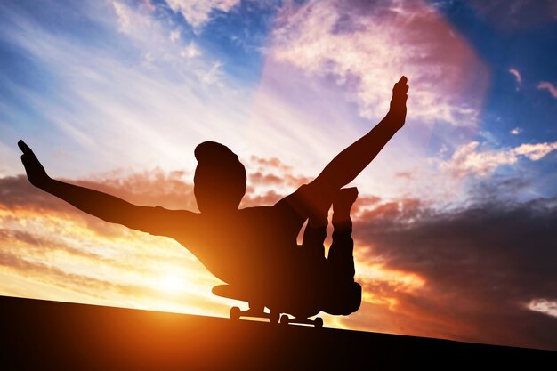 Jovem, deitado no skate ao pôr do sol.