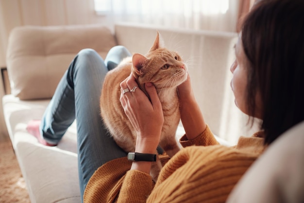 Jovem descansando com animal de estimação no sofá em casa