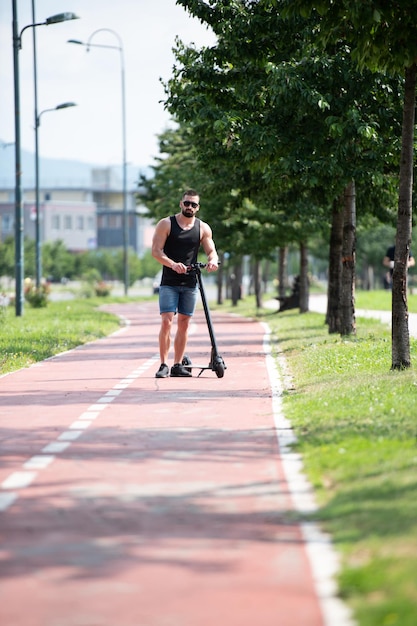 Jovem descansando depois de andar de scooter elétrica no verão na rua