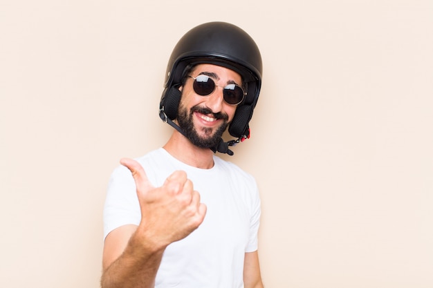 Jovem descolado barbudo com um capacete satisfeito e feliz