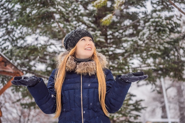 Jovem desfruta de um dia de inverno com neve em uma floresta de neve