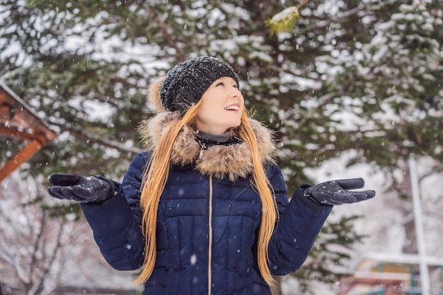 Jovem desfruta de um dia de inverno com neve em uma floresta de neve