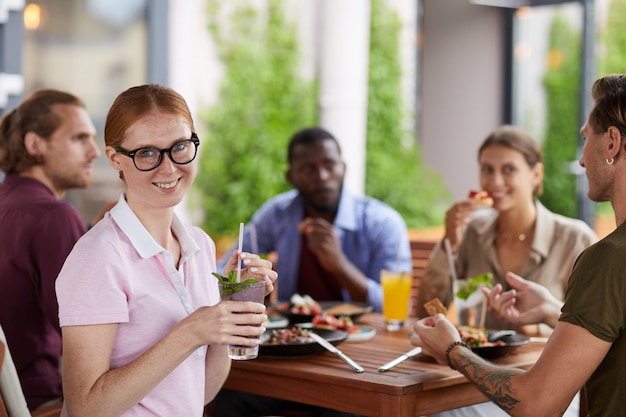 Jovem, desfrutando de almoço com amigos no café