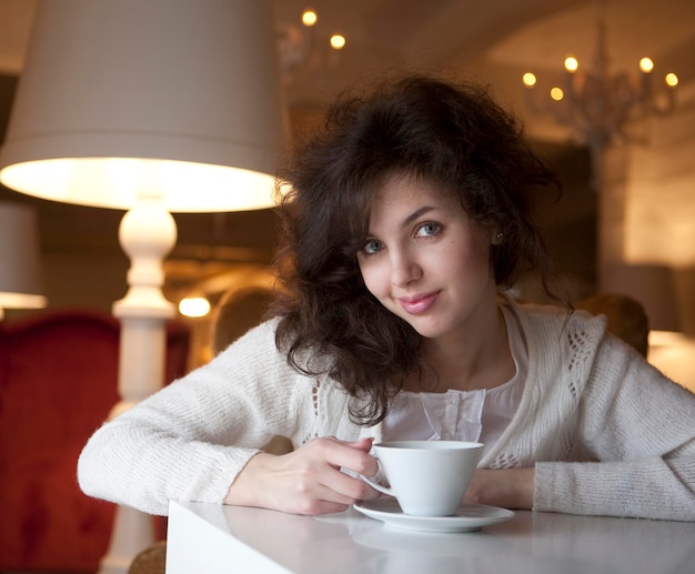 Jovem, desfrutando de café com leite no café