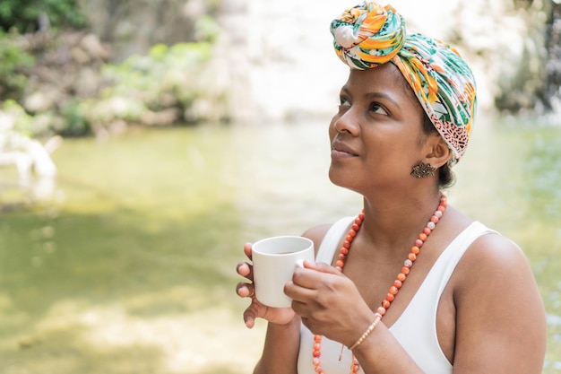 Jovem desfrutando de café da manhã à beira do rio