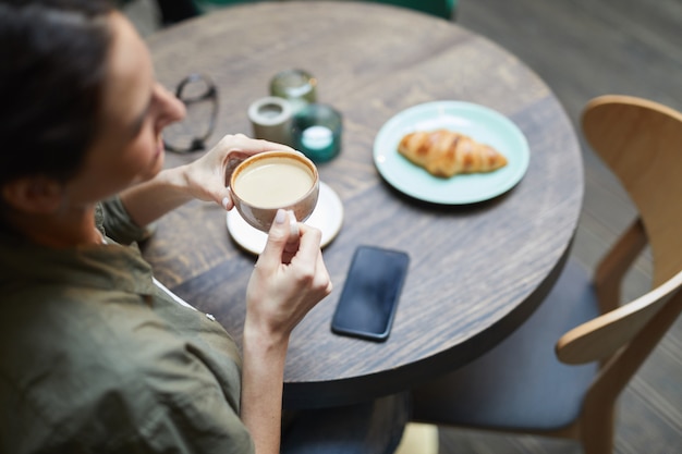 Jovem, desfrutando de café no café