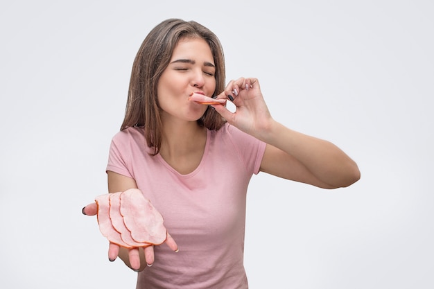 Jovem, desfrutando de comer carne