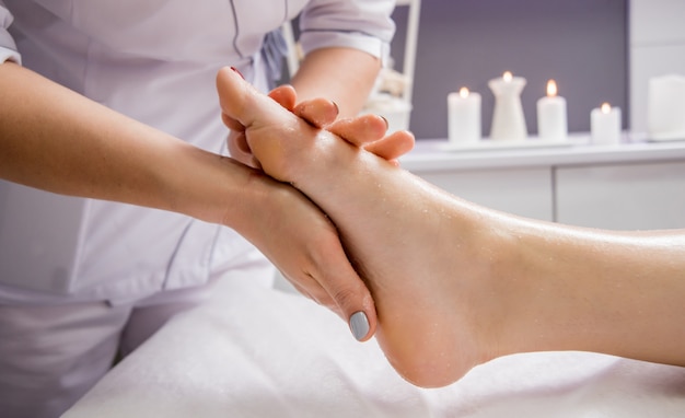 jovem desfrutando de massagem nos pés no salão spa. Cosmetologia