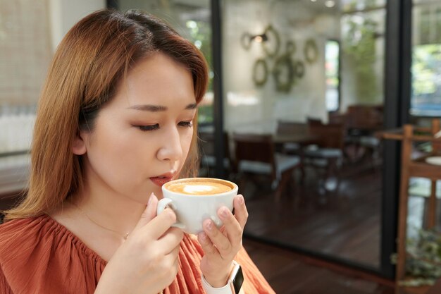 Jovem desfrutando de uma xícara de café saboroso pela manhã